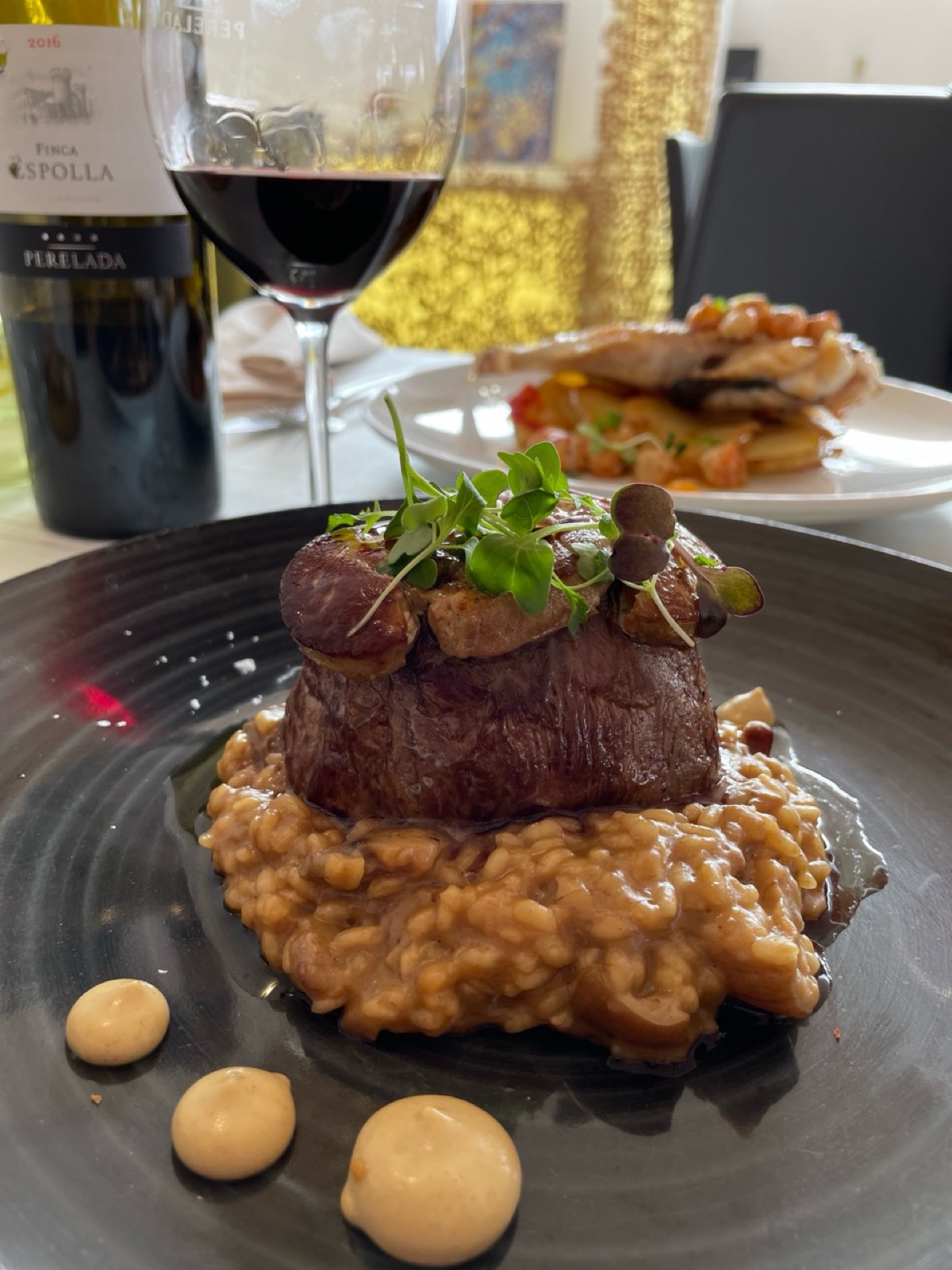 Carne con risotto servida en Essencia Restaurant